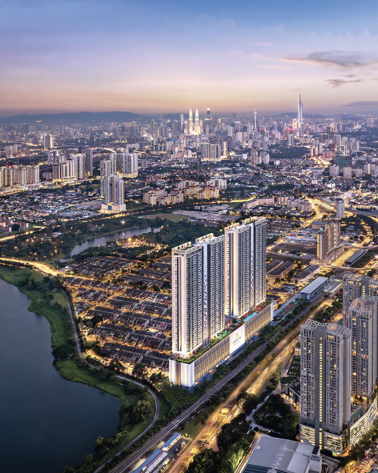 Taman Wahyu at dusk from the air: Han-Ya Wahyu's two towers beside the rail line, lakes in the foreground and the Kuala Lumpur skyline on the horizon